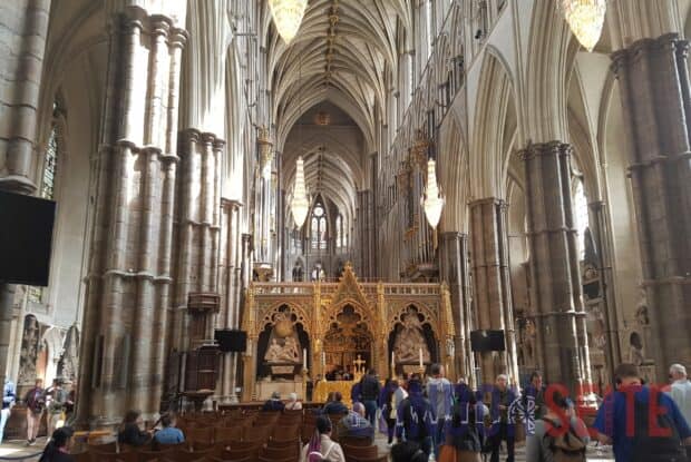 The interior of Westminster Abbey shows detailed gothic architecture and people exploring, 2K Desktop Wallpaper