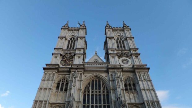 The Westminster Abbey stands tall under the clear blue sky with intricate Gothic details, HD Desktop Wallpaper
