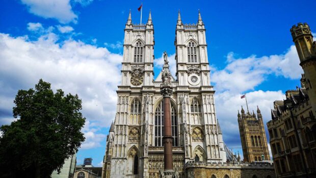 Westminster Abbey stands tall under a partly cloudy sky with surrounding historic buildings, HD Desktop Wallpaper