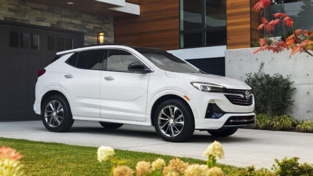 A white Buick Encore is parked in the driveway of a modern home with wooden and concrete accents, 4K Desktop Wallpaper