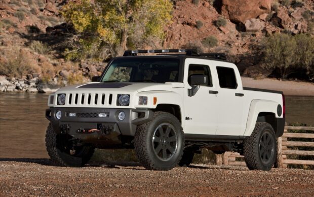 A white Hummer H3 is parked near a river with rocky terrain and trees in the background, HD Desktop Wallpaper