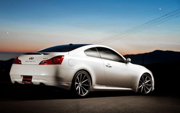 A white Infiniti G37 coupe is parked on a road during sunset with mountains in the background, HD Desktop Wallpaper