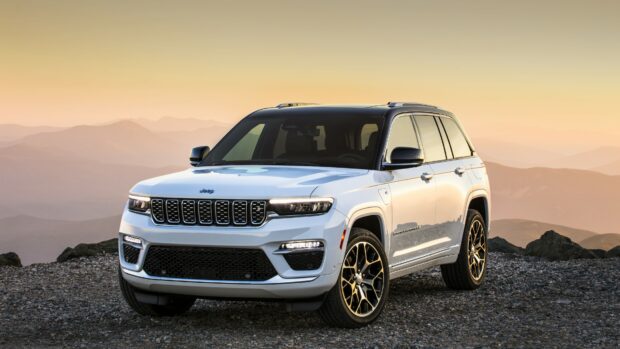 A white Jeep Grand Cherokee is parked on rocky terrain with mountains in the background at sunset, 4K Desktop Wallpaper