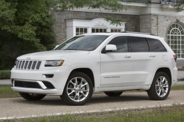 A white Jeep Grand Cherokee is parked on the driveway in front of a brick house with trees nearby, HD Desktop Wallpaper