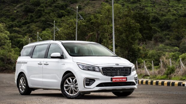 The white Kia car is parked on a roadside near green hills, HD Desktop Wallpaper