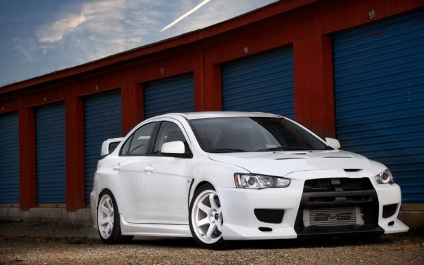 A white Lancer Evo car parked in front of blue storage doors during daytime, HD Desktop Wallpaper