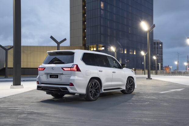 A white Lexus LX SUV is parked on an urban rooftop with city lights in the background, 2K Desktop Wallpaper