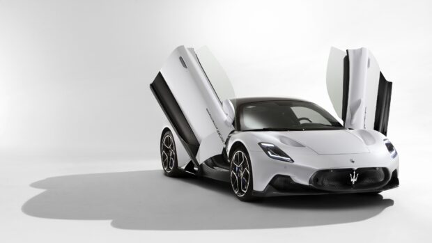 The Maserati MC20 showcases its sleek design with distinctive open doors in a white studio, 4K Desktop Wallpaper