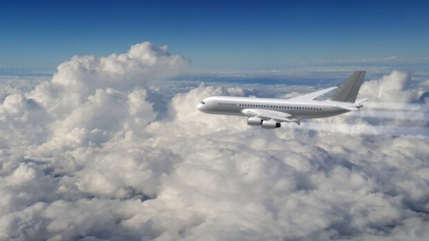 A white aircraft flying above thick clouds is captured in this clear blue sky, HD Desktop Wallpaper