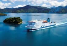 The white ferry sails through clear blue water surrounded by small green islands and mountains, HD Desktop Wallpaper