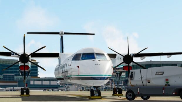 A white turboprop aircraft is parked on the runway at an airport with maintenance equipment nearby, 4K Desktop Wallpaper