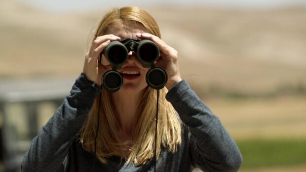 A woman is closely observing the landscape using binoculars in Homeland Wallpapers, HD Desktop Wallpaper