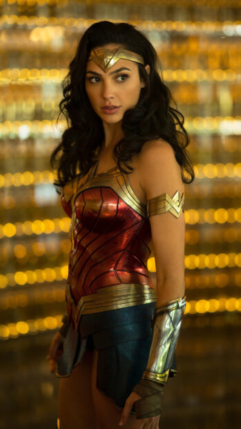 A woman dressed as Wonder Woman stands confidently with her head turned to the side, 4K Phone Wallpaper