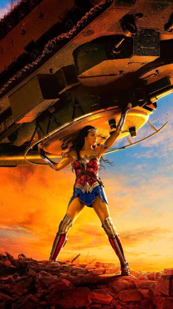Wonder Woman is shown using her strength to lift a tank amidst a battlefield at sunset, 2K Phone Wallpaper