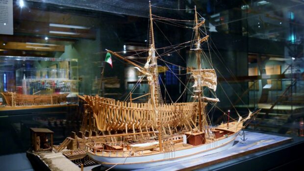 A detailed wooden ship model displayed at the maritime museum exhibits traditional shipbuilding techniques, 2K Desktop Wallpaper