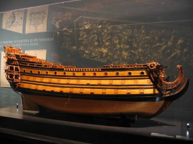 A detailed wooden ship model is displayed as part of maritime museum exhibits, HD Desktop Wallpaper