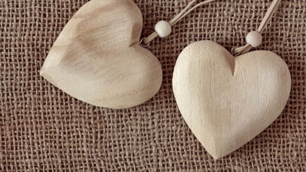 Two wooden heart shapes hang on a brown woven background, HD Desktop Wallpaper