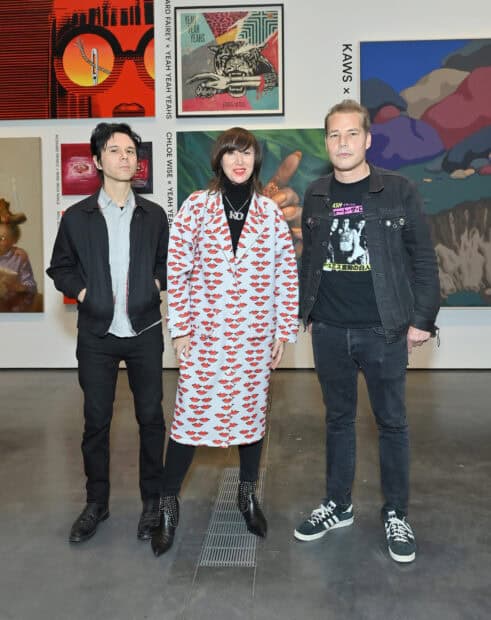 The Yeah Yeah Yeahs band stands together in an art gallery setting, 2K Desktop Wallpaper