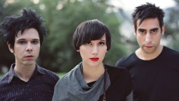 The Yeah Yeah Yeahs band members pose outdoors in a natural setting, HD Desktop Wallpaper