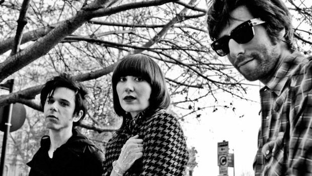 The Yeah Yeah Yeahs band members pose under tree branches in this black and white image, HD Desktop Wallpaper