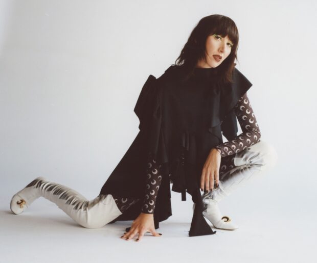A member of Yeah Yeah Yeahs poses in a black dress and patterned sleeves, HD Desktop Wallpaper
