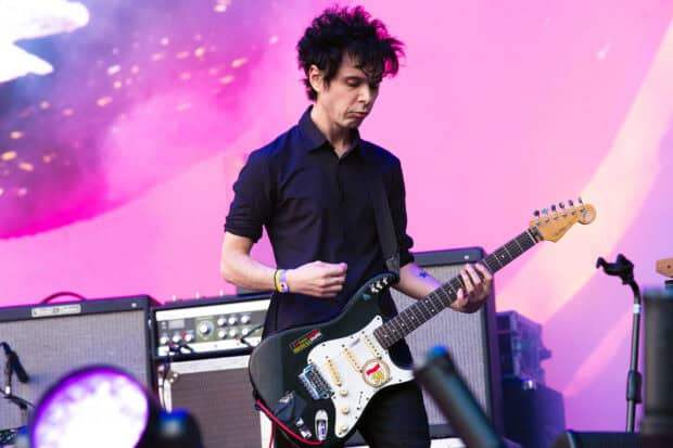 A guitarist is playing electric guitar during a Yeah Yeah Yeahs concert on stage, HD Desktop Wallpaper