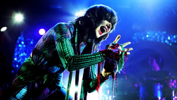 The lead singer of Yeah Yeah Yeahs is passionately performing on stage, HD Desktop Wallpaper