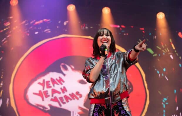 A band member of Yeah Yeah Yeahs is singing on stage with colorful lights, HD Desktop Wallpaper