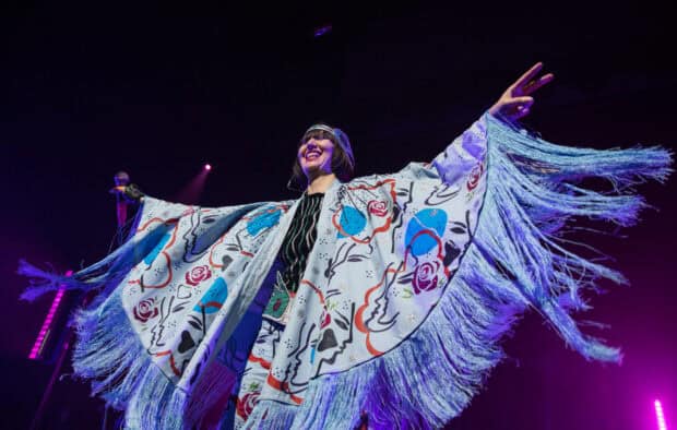 The lead singer of Yeah Yeah Yeahs wears a colorful fringed outfit on stage, 2K Desktop Wallpaper
