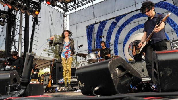 The Yeah Yeah Yeahs perform on stage with vibrant energy and colorful outfits, HD Desktop Wallpaper