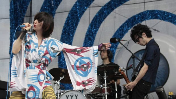 A band performing live on stage at a music festival with vibrant costumes and instruments, HD Desktop Wallpaper