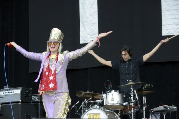 The Yeah Yeah Yeahs lead singer celebrates with arms wide open during concert, 2K Desktop Wallpaper