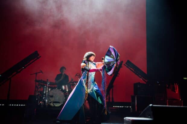 A singer is passionately performing with a vibrant dress during a concert, HD Desktop Wallpaper