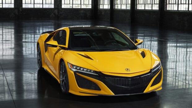 A yellow Honda NSX sports car is parked inside an industrial warehouse with large windows, 2K Desktop Wallpaper