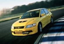 A yellow Lancer Evo is racing on a curving track with motion blur visible, HD Desktop Wallpaper