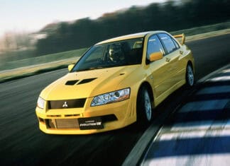 A yellow Lancer Evo is racing on a curving track with motion blur visible, HD Desktop Wallpaper