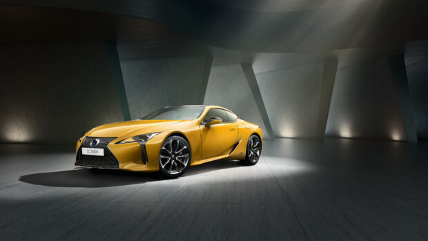 A yellow Lexus LC 500h sports car is showcased in a futuristic concrete space with dramatic lighting, 2K Desktop Wallpaper