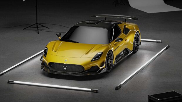 A yellow Maserati Mc20 is positioned in a studio surrounded by lights, showcasing its sleek design, HD Desktop Wallpaper