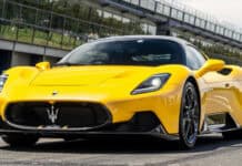 A yellow Maserati Mc20 sports car is parked near a modern building on a sunny day, HD Desktop Wallpaper