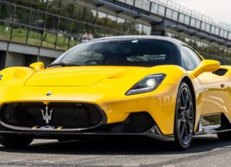 A yellow Maserati Mc20 sports car is parked near a modern building on a sunny day, HD Desktop Wallpaper