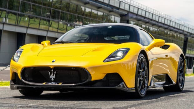 A yellow Maserati Mc20 sports car is parked near a modern building on a sunny day, HD Desktop Wallpaper