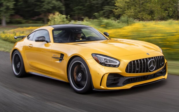 A yellow Mercedes Benz AMG GT is driving outdoors on a road surrounded by greenery, HD Desktop Wallpaper