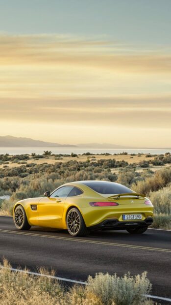 A yellow Mercedes Benz AMG GT is parked on a desert road during sunset, HD Mobile Wallpaper