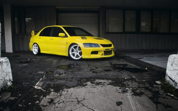 A yellow Mitsubishi Lancer Evo is parked in a dark urban area, HD Desktop Wallpaper