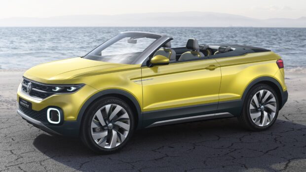 A yellow Volkswagen T Cross convertible is parked near a beach with ocean waves in the background, 2K Desktop Wallpaper