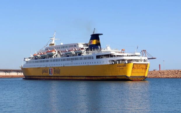 A yellow ferry is sailing on calm sea water near the coastline under a clear blue sky with no clouds, HD Desktop Wallpaper