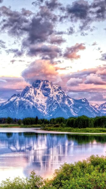 The sunrise over a mountain and lake in Yellowstone National Park creates a peaceful scene, 2K Phone Wallpaper