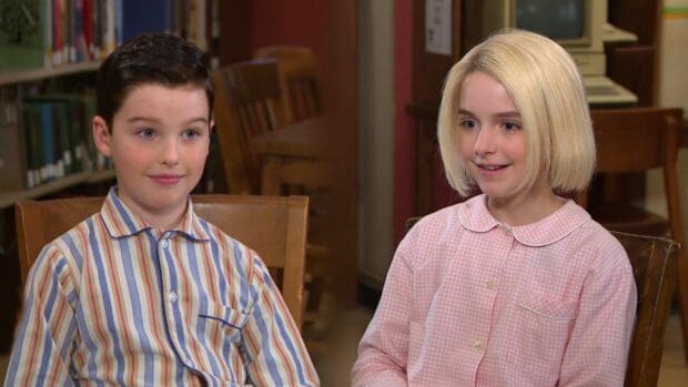 Two children from Young Sheldon tv series sit in a library setting with wooden chairs and shelves behind them, HD Desktop Wallpaper