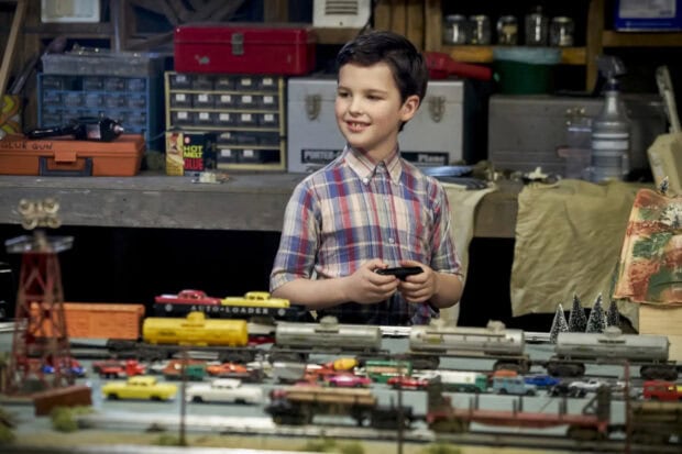 A young boy from Young Sheldon tv series playing with a detailed train model in a workshop, HD Desktop Wallpaper