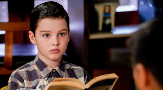 A young boy from Young Sheldon tv series is attentively reading a book at home, 2K Desktop Wallpaper